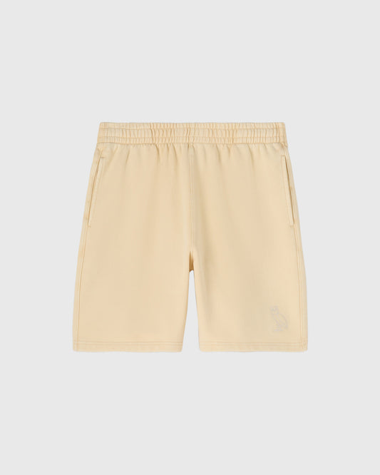 Cream-colored shorts with elastic waistband, side pockets, and center seam detail.