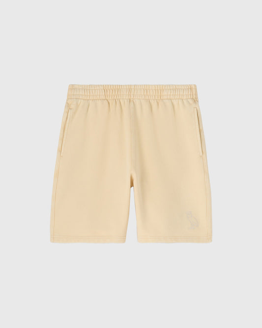 Cream-colored garment-dyed shorts with elastic waistband and side pockets.