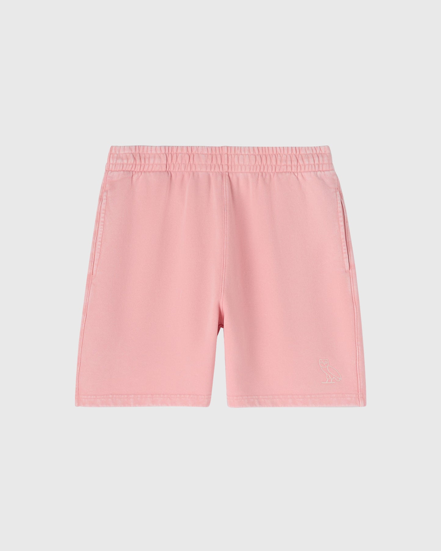 Pink garment-dyed shorts with elastic waistband and embroidered owl logo on thigh.