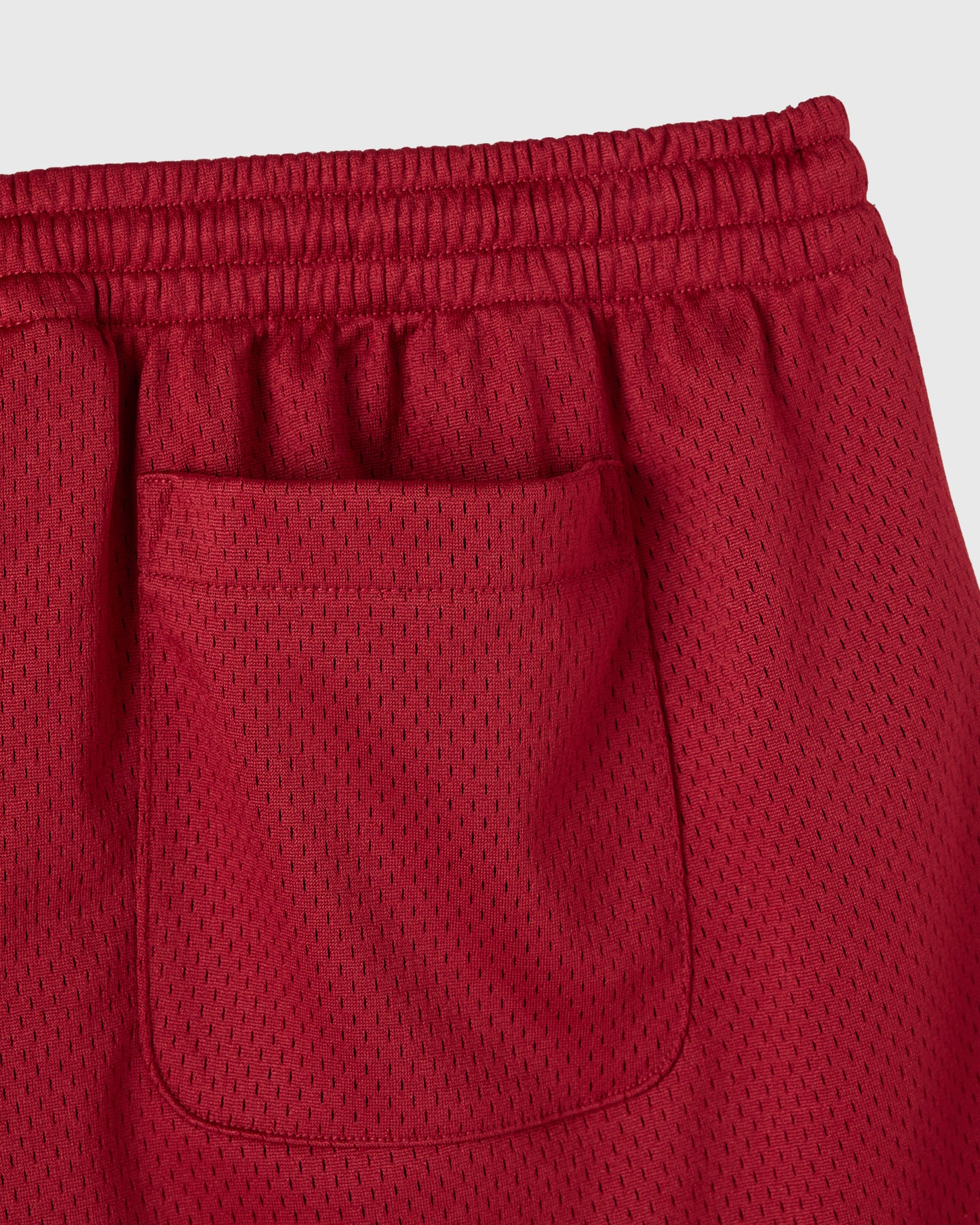 Deep red mesh shorts with elastic waistband and front pocket detail.