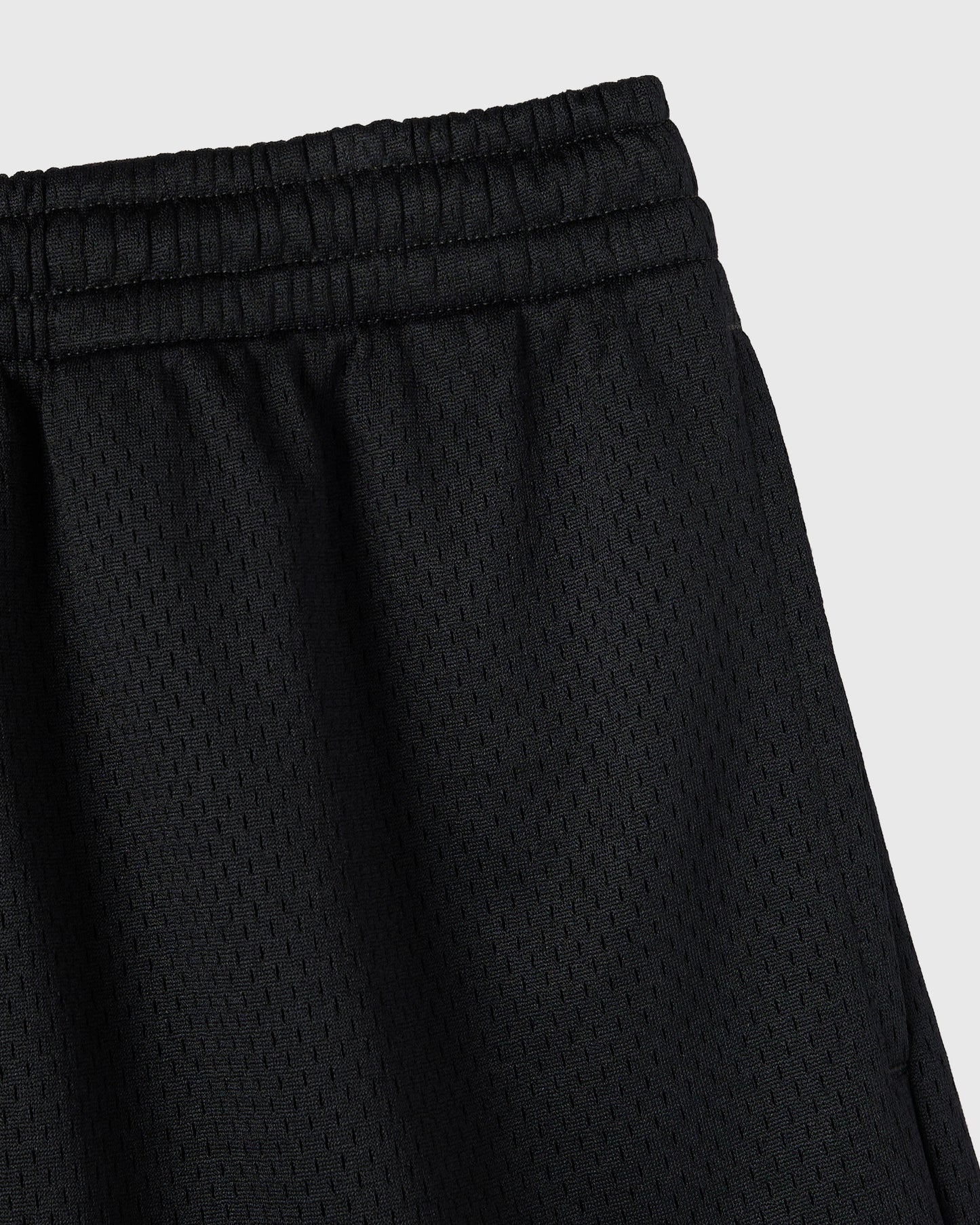Black mesh shorts with elasticated waistband and textured fabric.