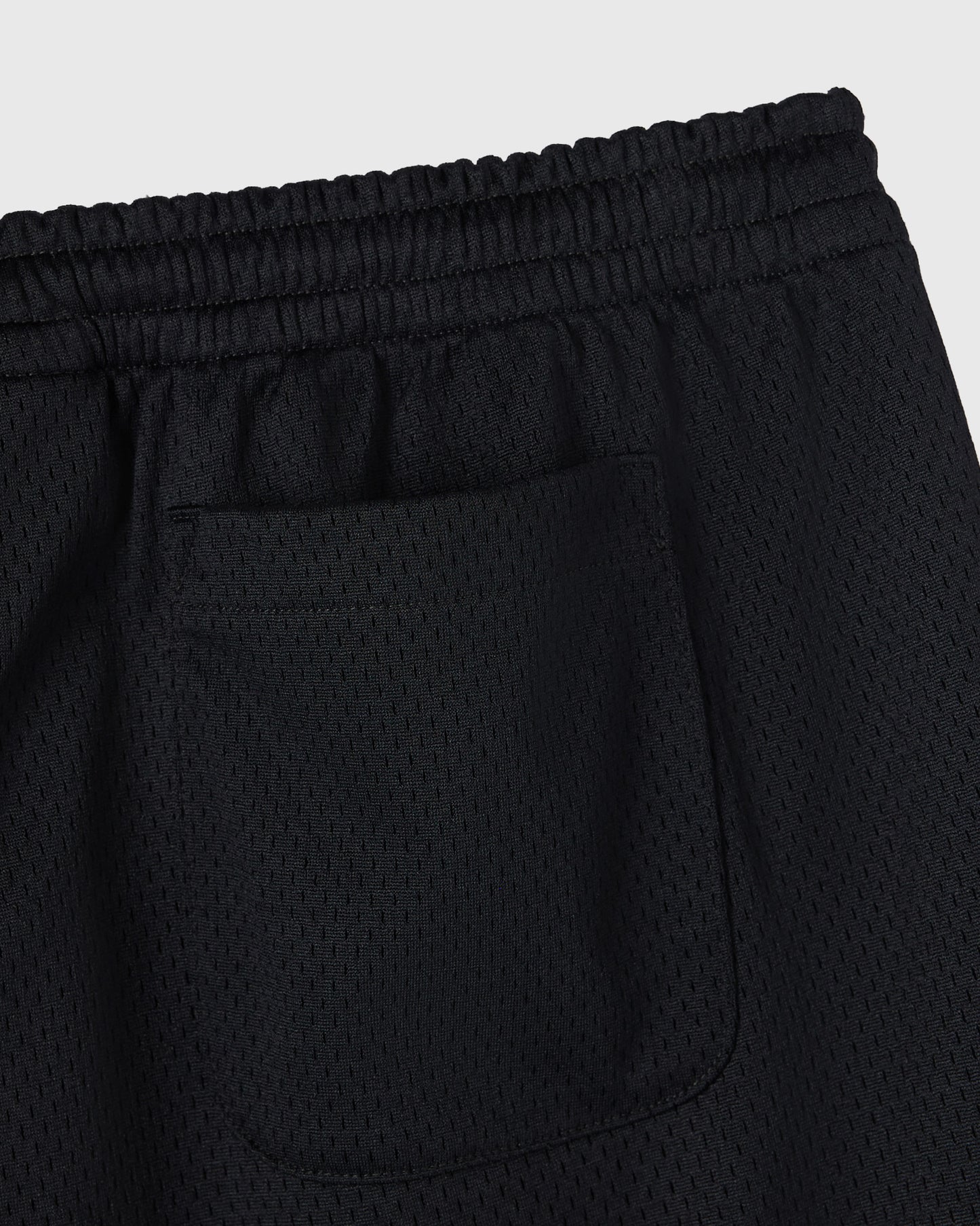 Black mesh shorts with elastic waistband and front pocket detail.