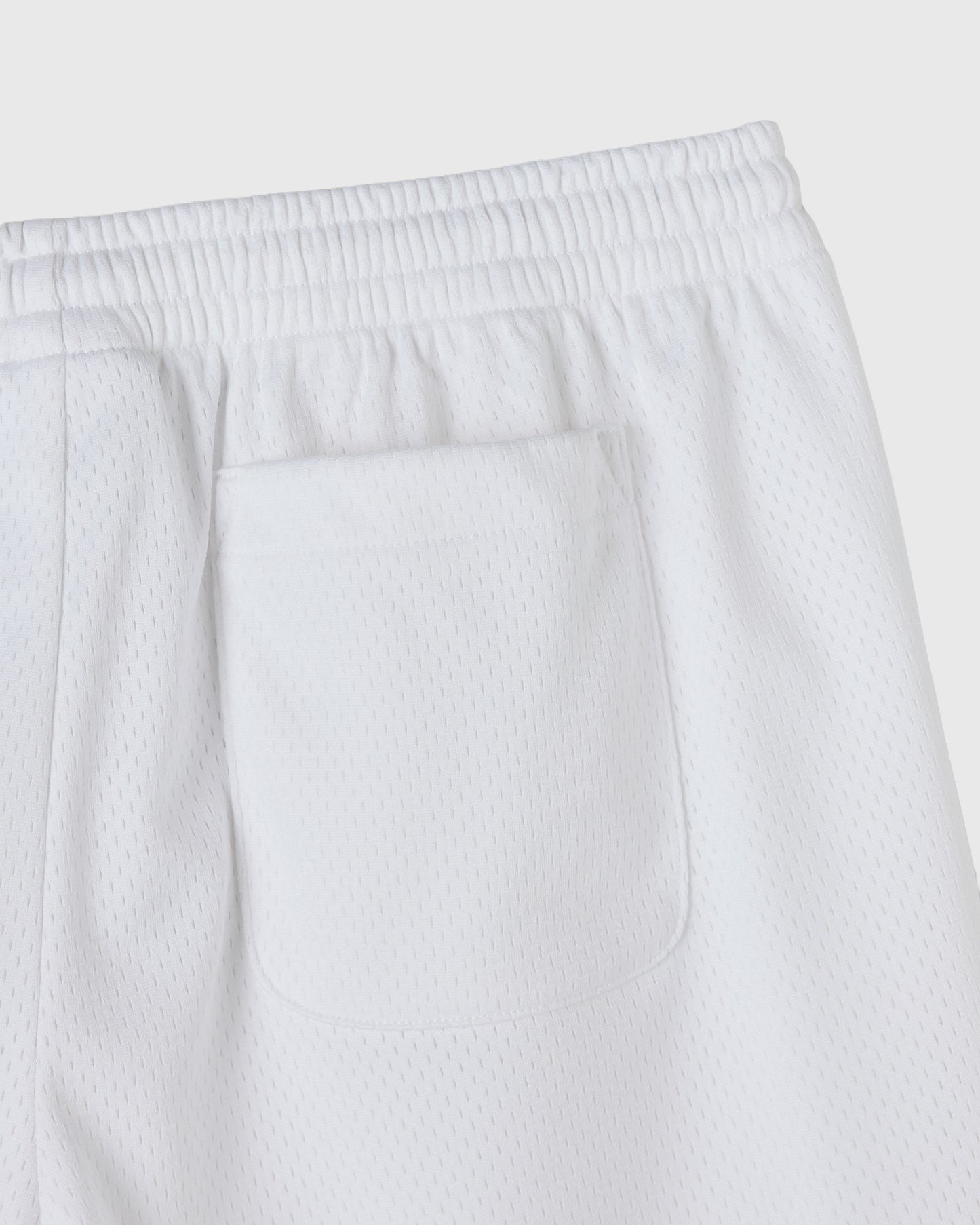 White mesh shorts with elasticated waistband and front patch pocket.