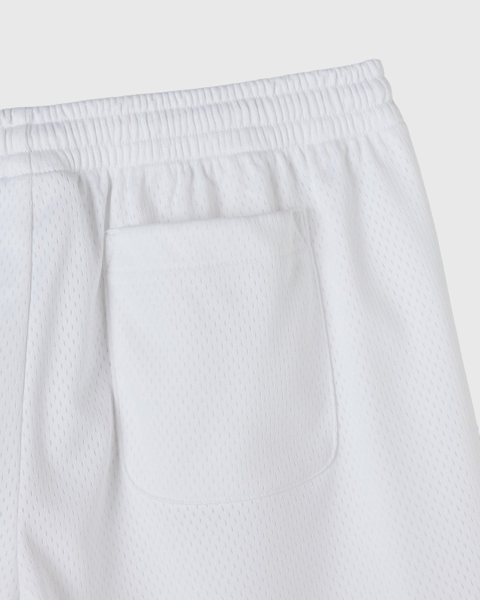 White mesh shorts with elasticated waistband and front patch pocket.