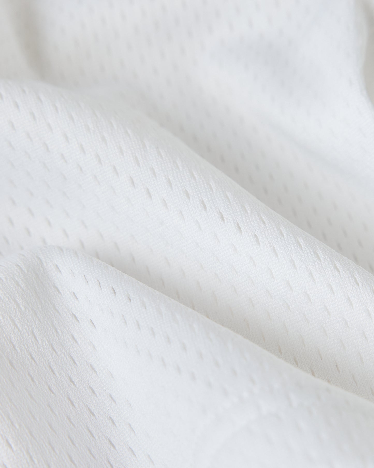 White mesh fabric with textured weave pattern and draped folds.