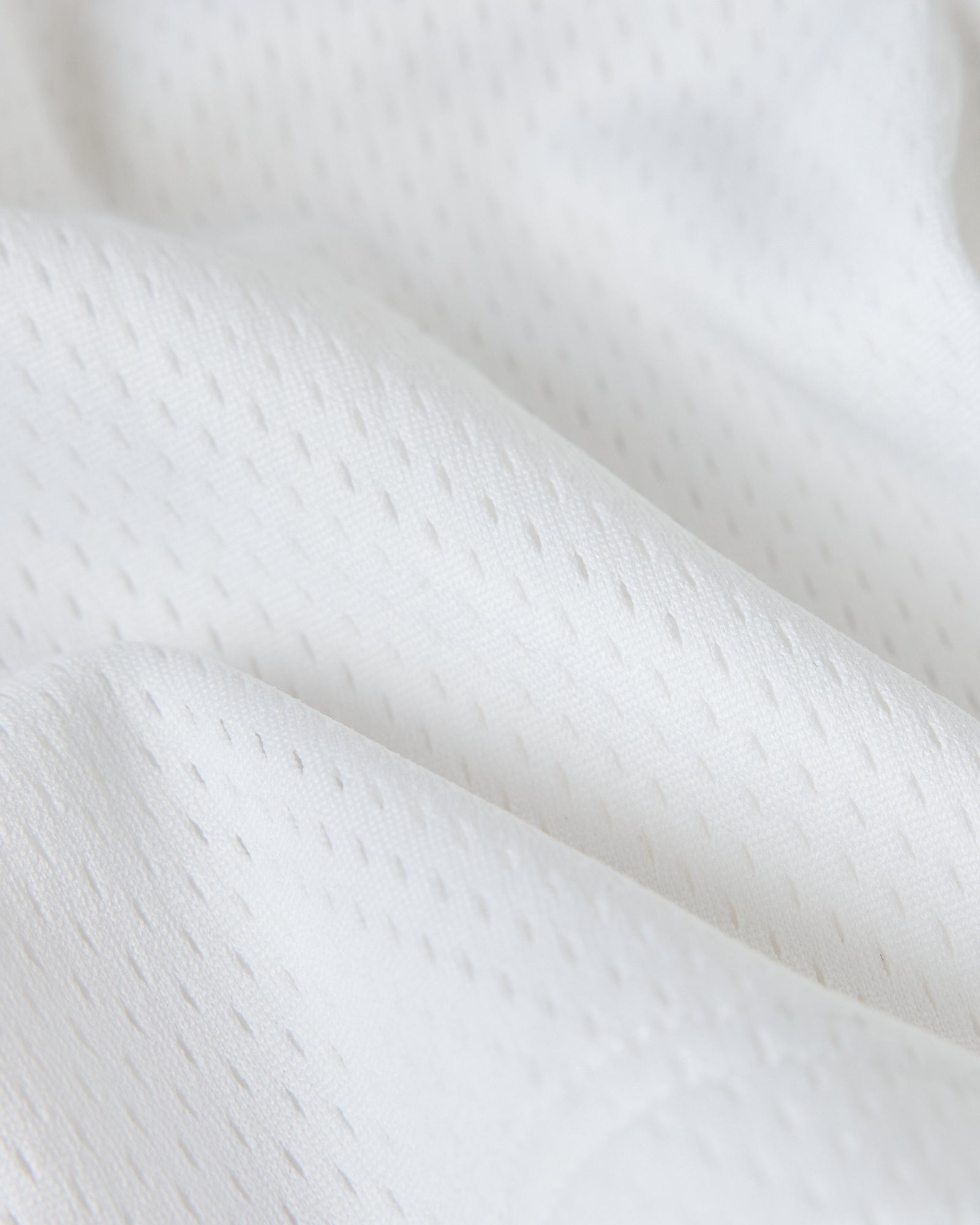 White mesh fabric with textured weave pattern and draped folds.