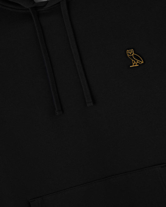 Black hoodie with gold owl embroidery on chest and drawstring visible.