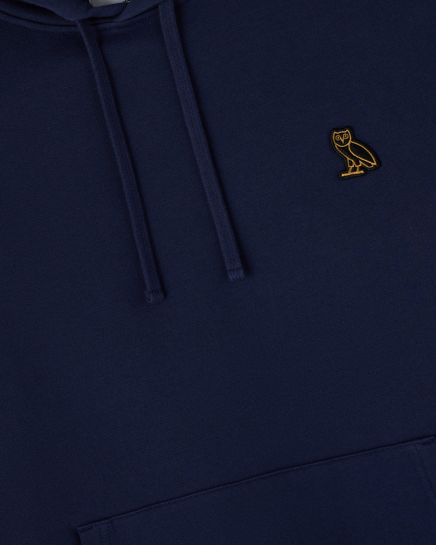 Navy hoodie with drawstring and small gold owl embroidered on chest.