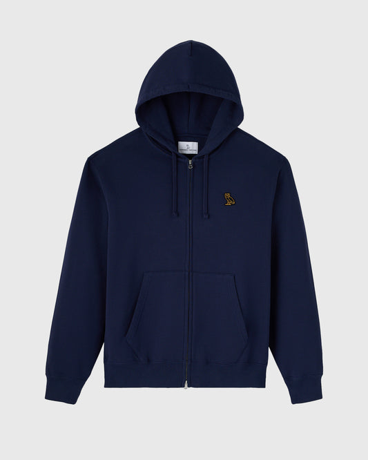 Navy full-zip hoodie with drawstring hood, front kangaroo pocket, and small gold embroidered logo on chest.