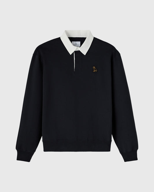 Black rugby polo with cream collar, quarter-zip front, and small embroidered bird logo on chest.