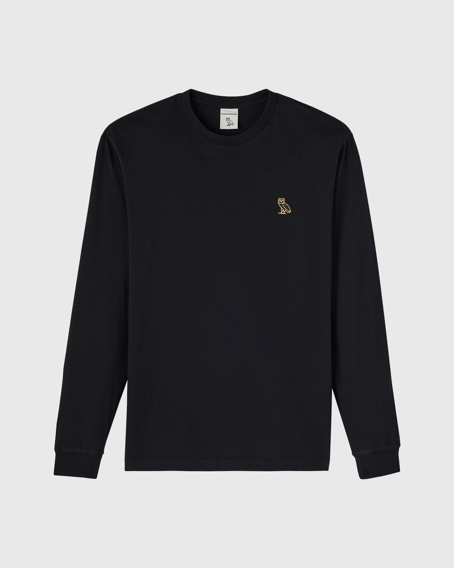 Black long-sleeve crewneck tee with small gold owl embroidered on chest.