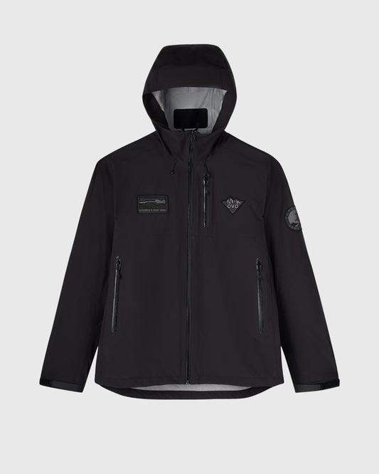Black hiking shell jacket with hood, chest badge details, side zip pockets, and gray inner lining visible.
