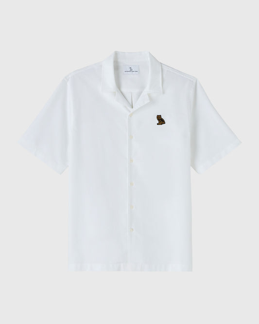 White short-sleeve camp shirt with button front closure and small embroidered bird logo on chest.