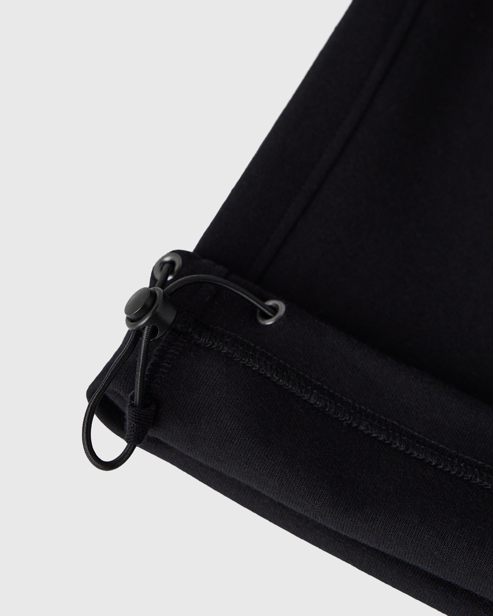 Black sweatpants with drawstring waistband and ribbed cuff detail.