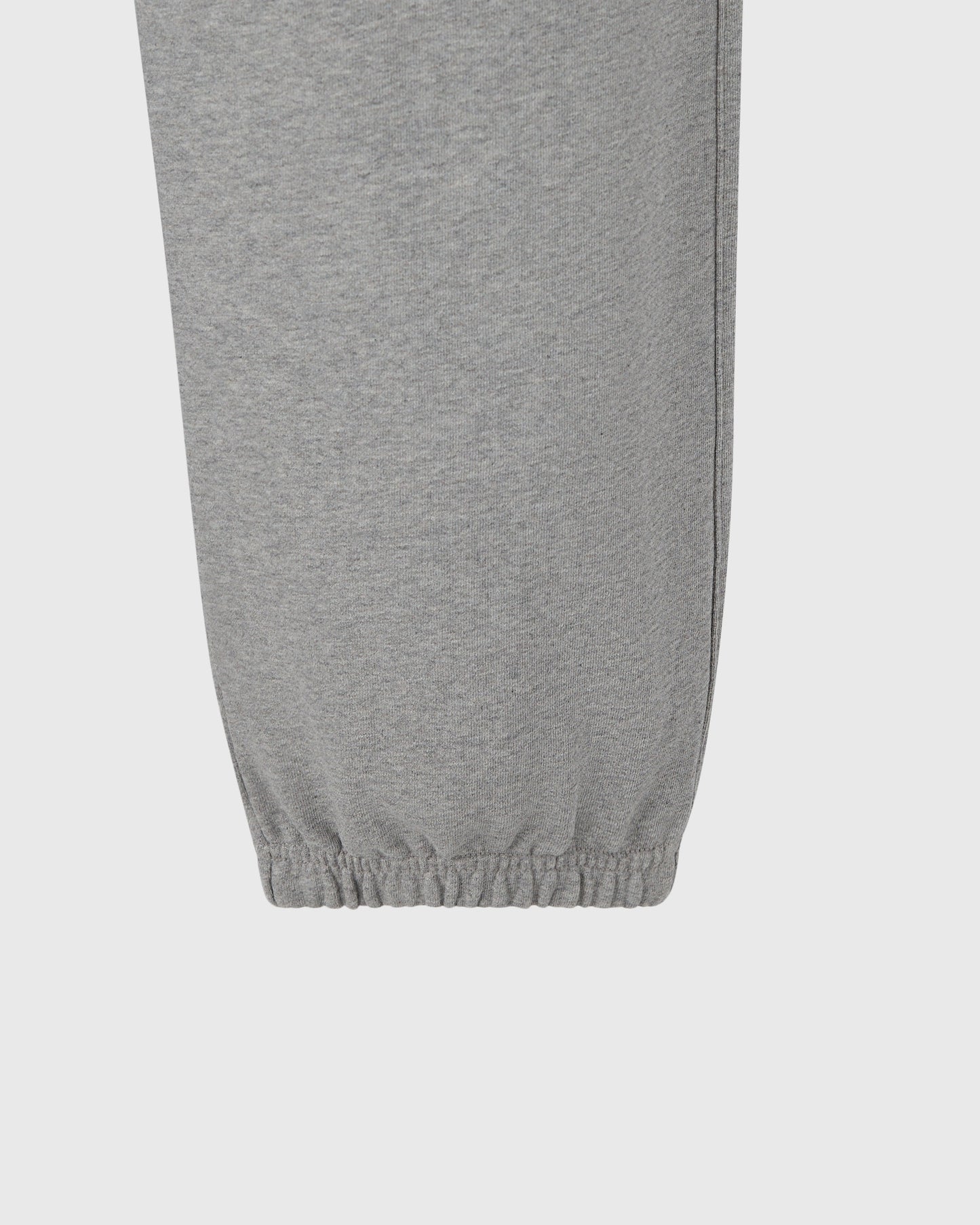 Heather grey sweatpant with elastic cuff at ankle, shown from waist down.
