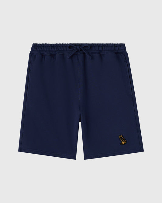 Navy sweatshorts with drawstring waist and small gold bird embroidery on leg.