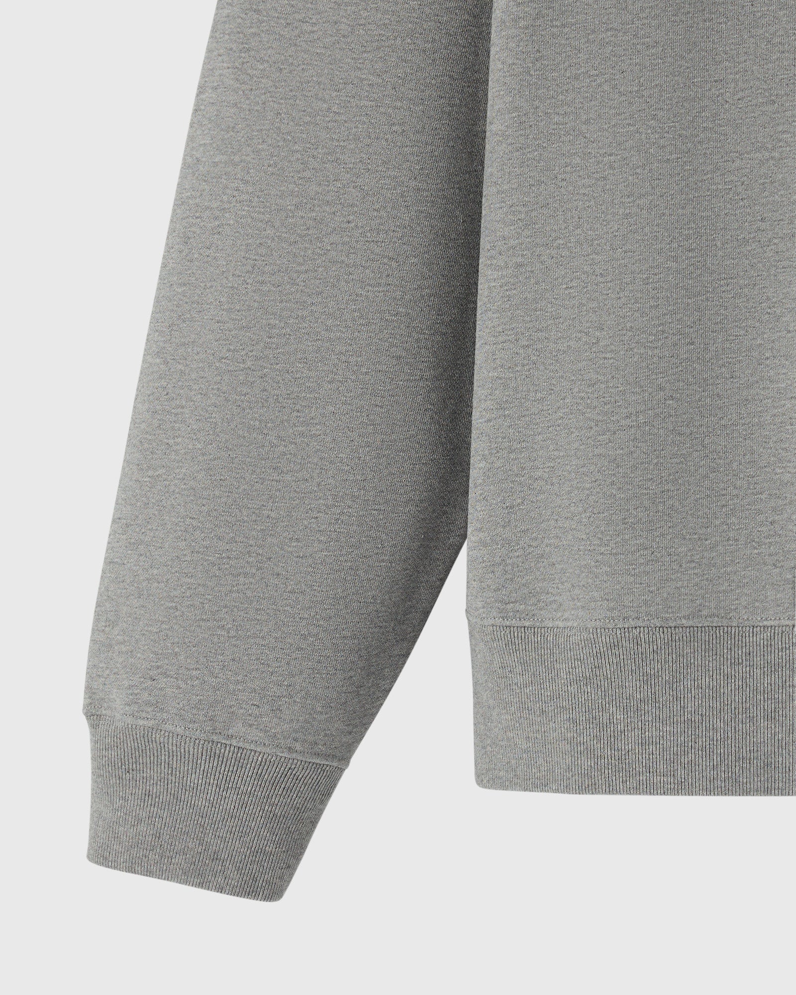 Heather grey crewneck sweatshirt with ribbed cuffs and hem, shown from torso detail view.