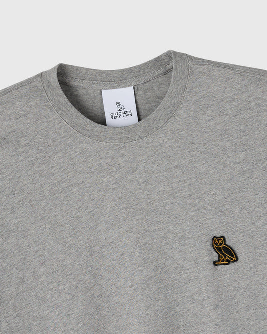 Heather grey crewneck t-shirt with small embroidered owl logo on chest and brand label at neckline.