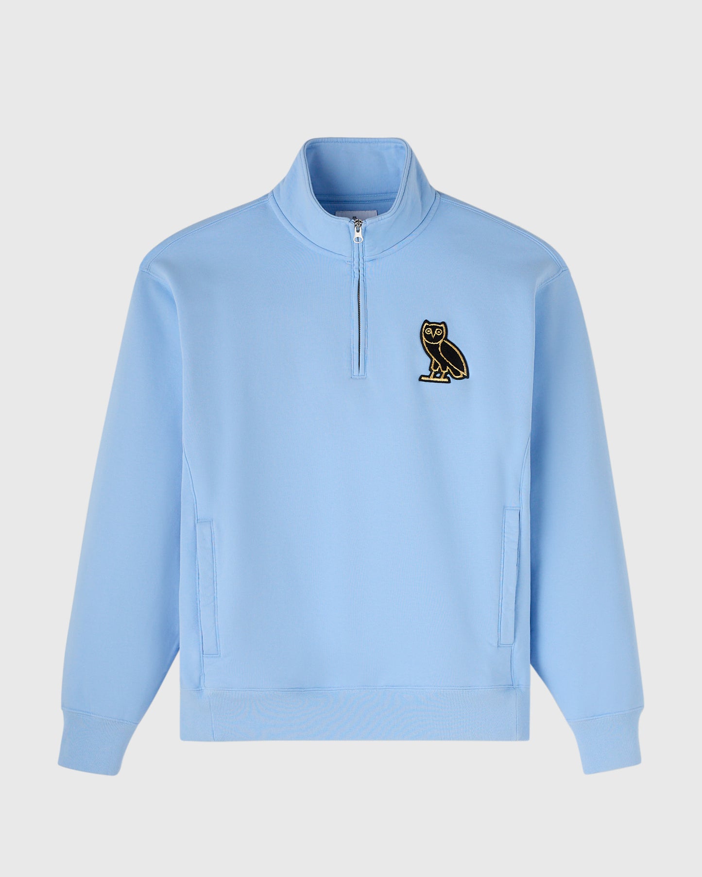 Light blue quarter-zip mockneck sweatshirt with owl embroidered on chest and front pockets.