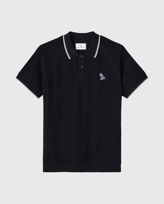 Black open knit polo shirt with white tipping on collar and sleeves, featuring small embroidered logo on chest.