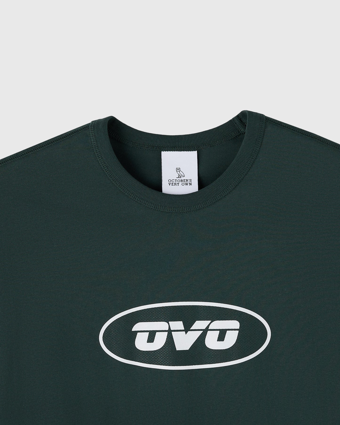 Midnight green muscle tee with white oval "OVO" logo print on chest and ribbed crew neckline.
