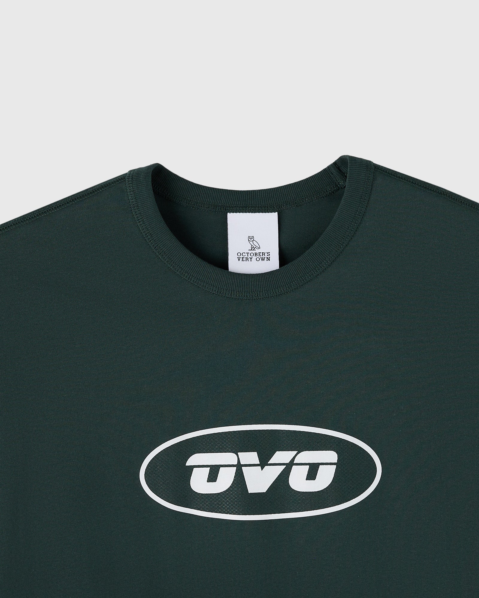 Midnight green muscle tee with white oval "OVO" logo print on chest and ribbed crew neckline.