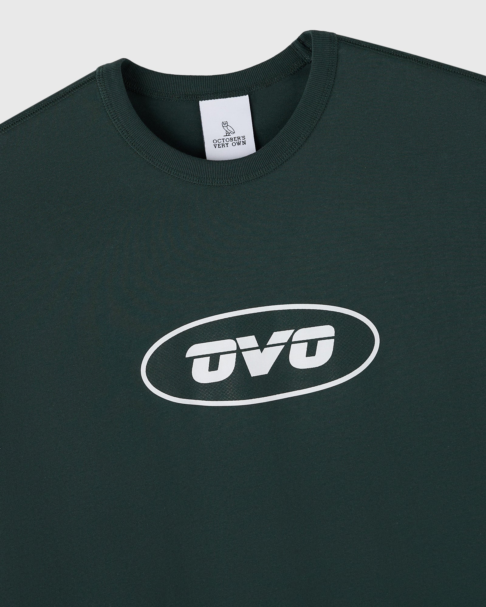 Midnight green muscle tee with white oval "OVO" logo print on chest and brand label at neckline.