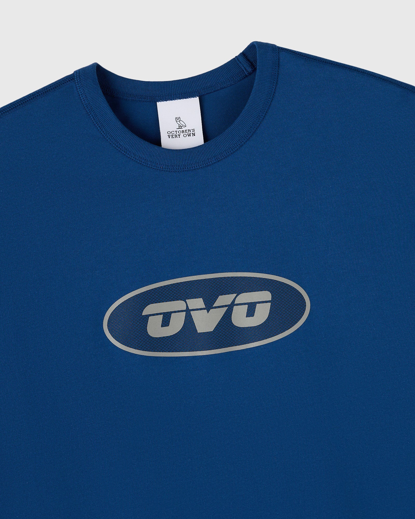 Deep denim muscle tee with gray oval "OVO" print on chest and crew neckline.