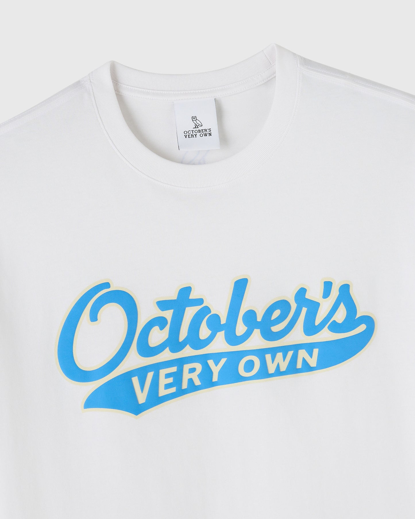 White t-shirt with blue "October's Very Own" sports script graphic on chest.