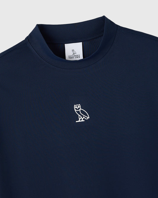 Deep denim mockneck tee with white owl logo on chest and brand label at neckline.