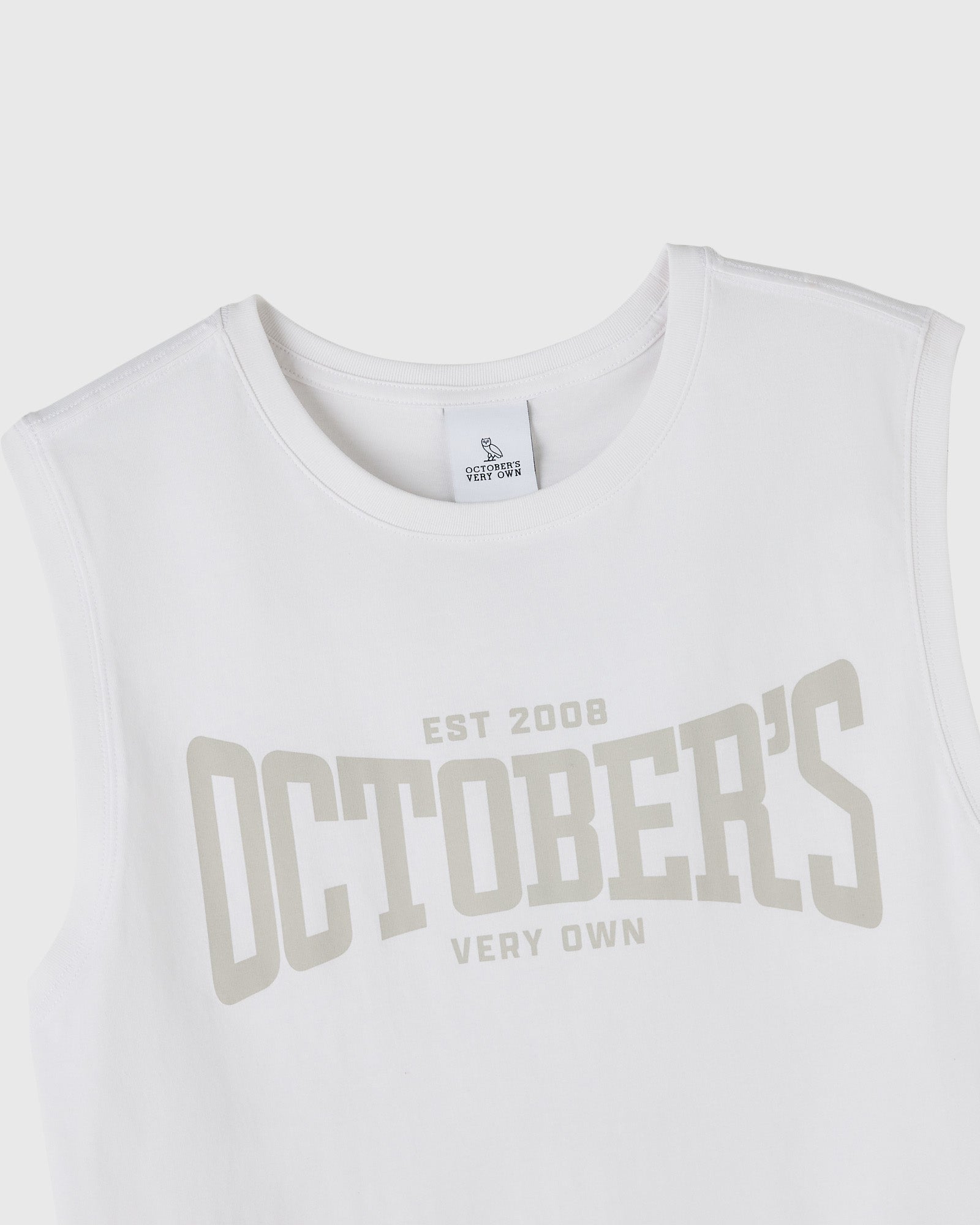 White sleeveless tank top with "EST 2008 OCTOBER'S VERY OWN" text printed in beige across the chest.
