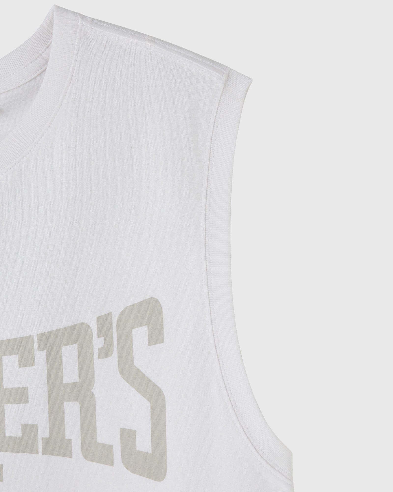 White sleeveless tank top with ribbed armholes and tan text graphic on chest.