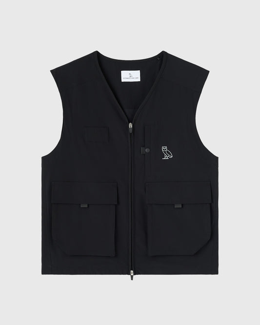 Black stretch nylon golf vest with front zip closure, chest pockets, and embroidered owl logo.