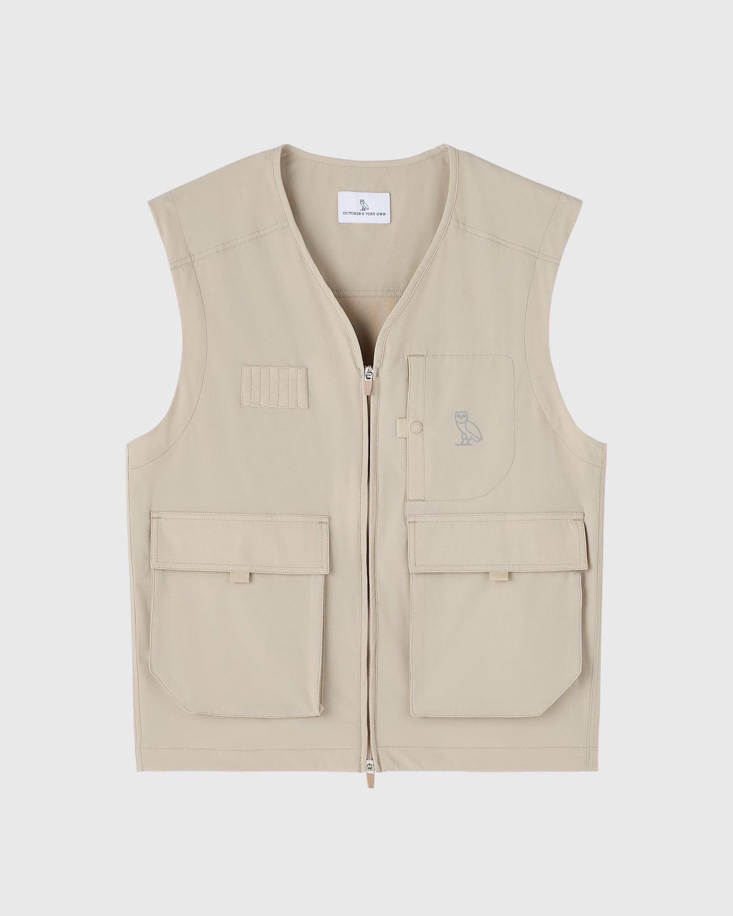 Sandstone nylon vest with front zip, multiple pockets, and small owl embroidery on chest.