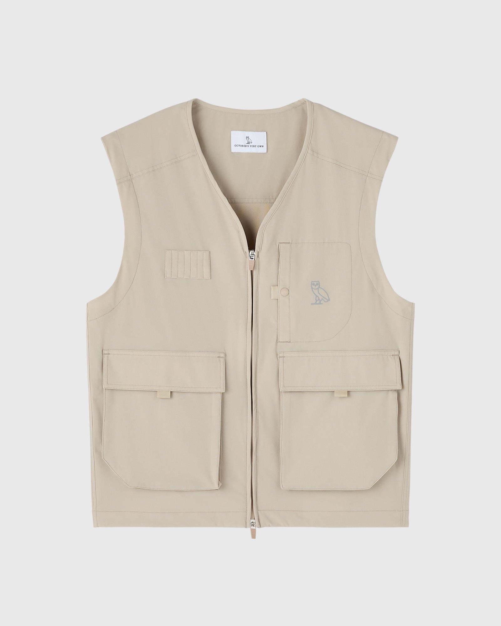 Sandstone nylon vest with front zip, multiple pockets, and small owl embroidery on chest.