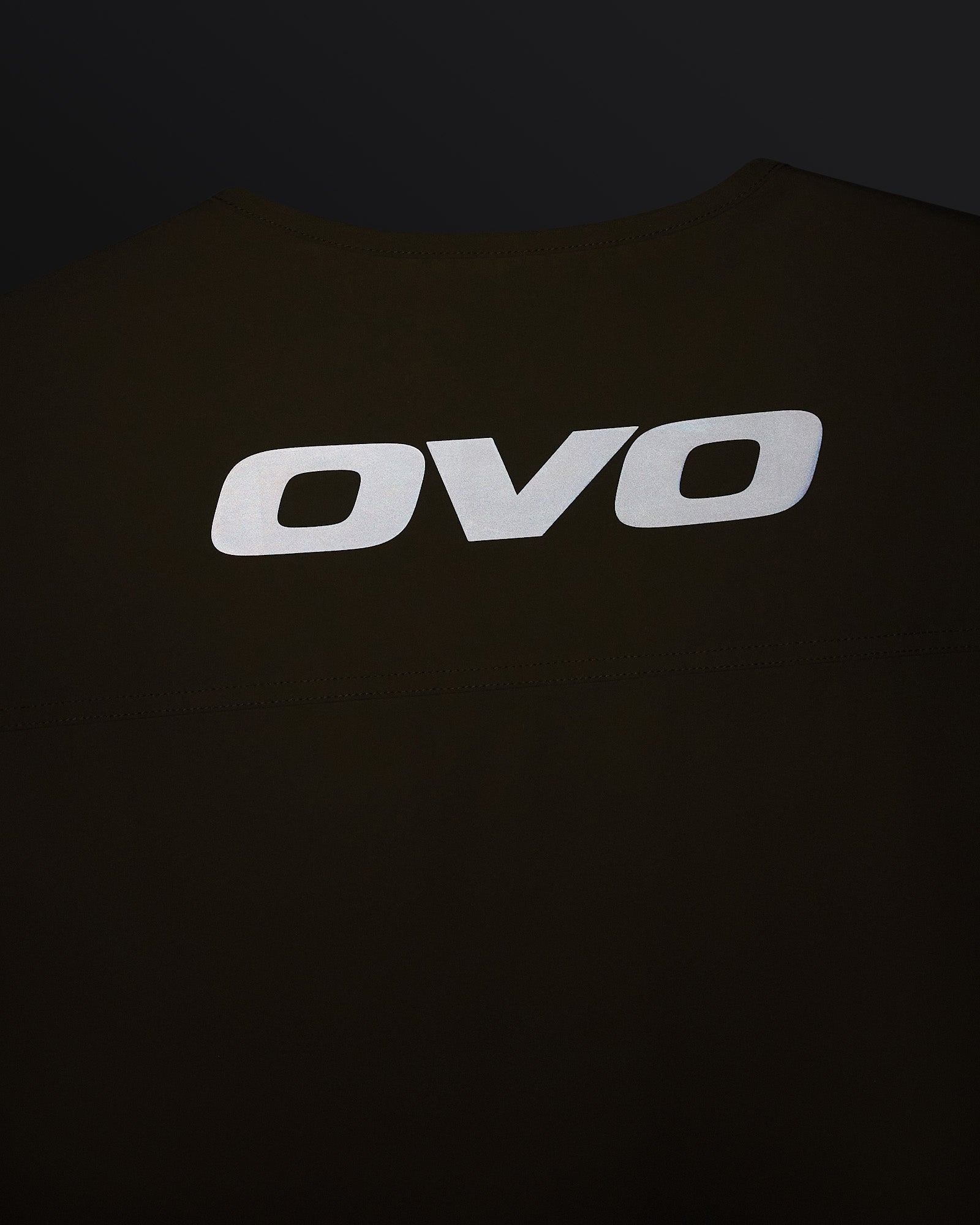 Sandstone-colored stretch nylon vest with white OVO logo on chest.