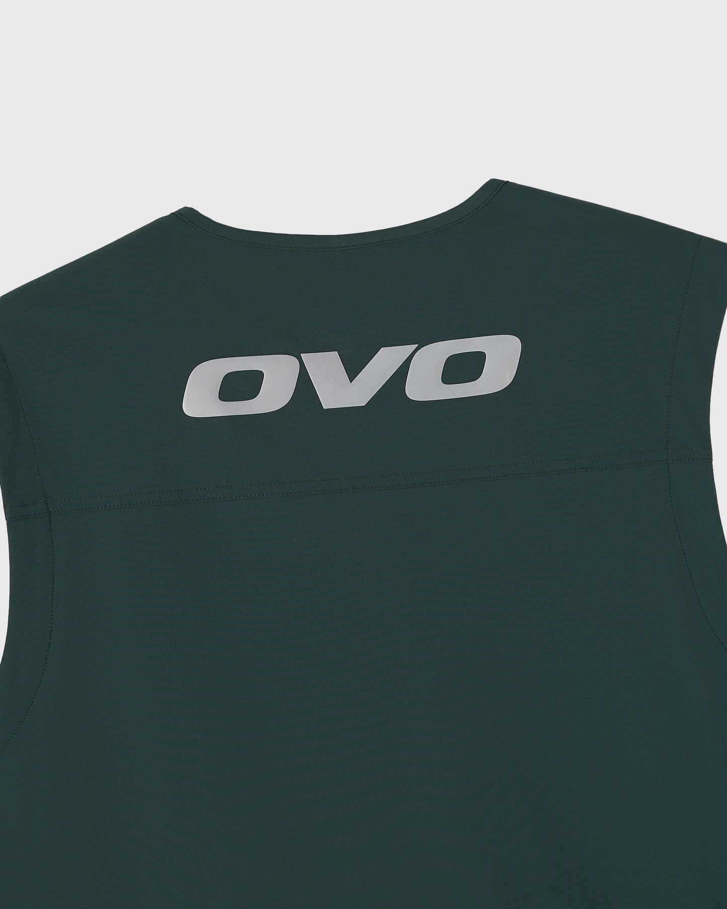 Midnight green sleeveless vest with OVO logo printed on back and white side stripe detail.