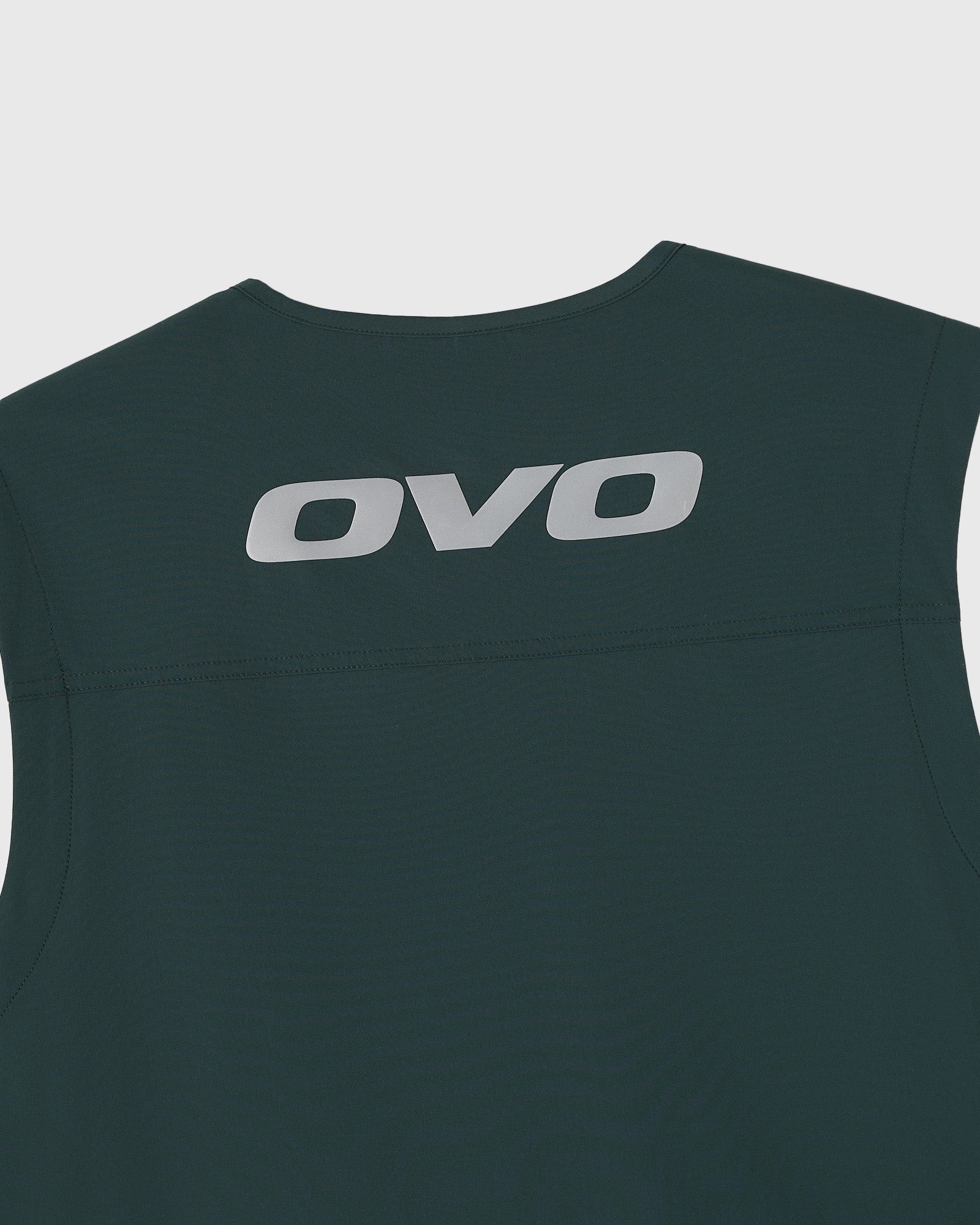 Midnight green sleeveless vest with OVO logo printed on back and white side stripe detail.