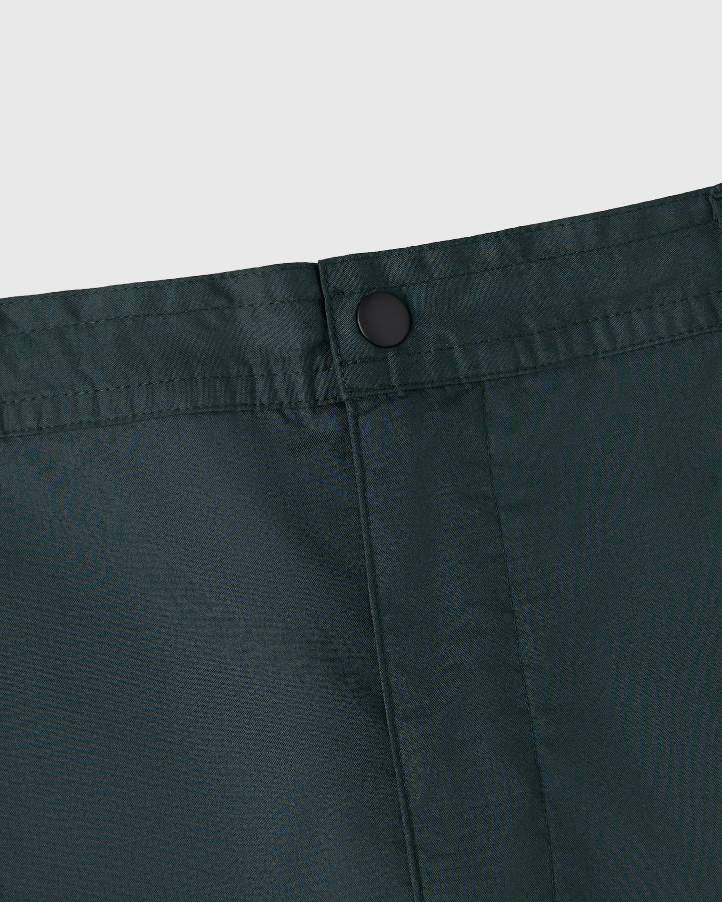 Midnight green camp short with button closure and front pleat detail.