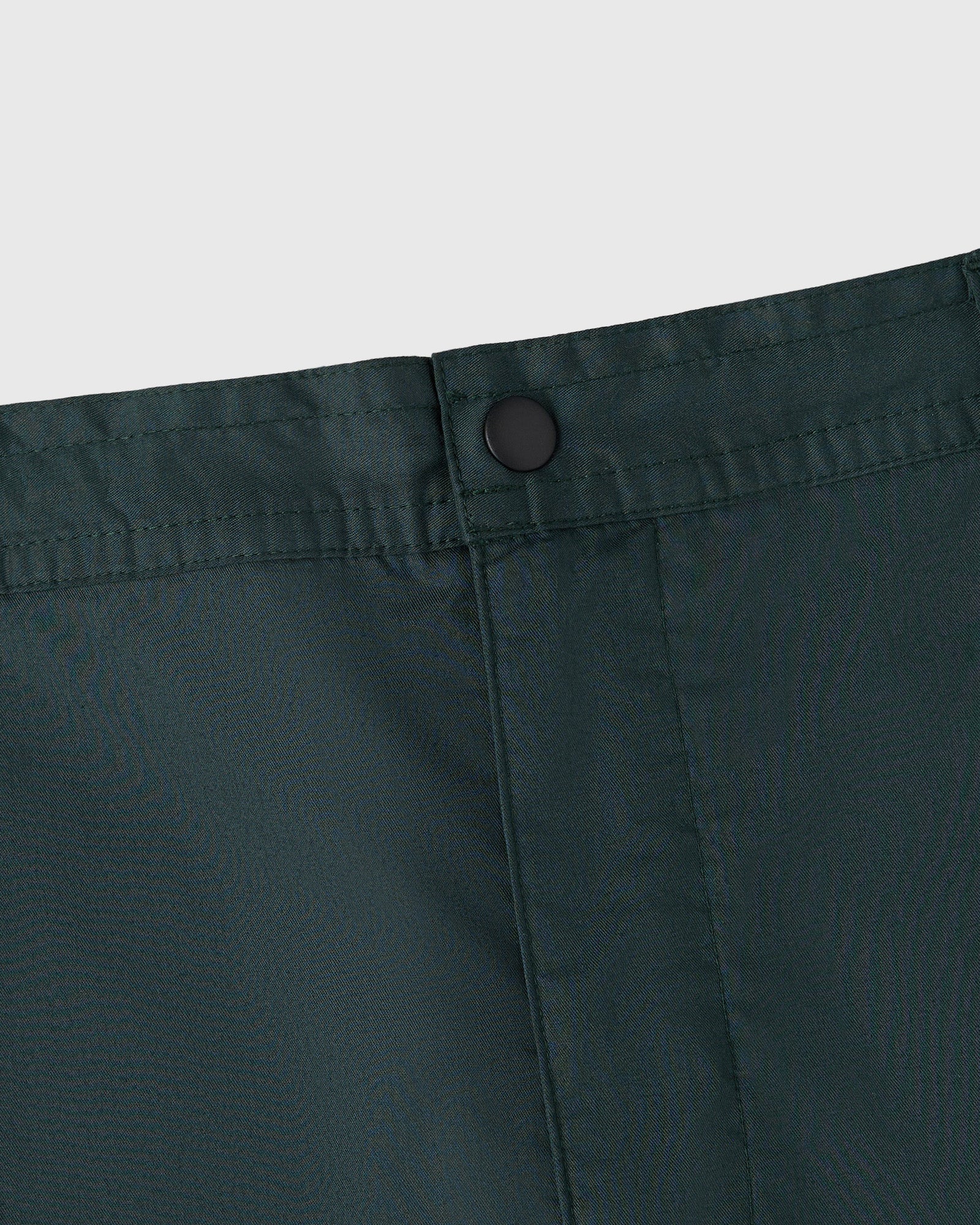 Midnight green camp short with button closure and front pleat detail.
