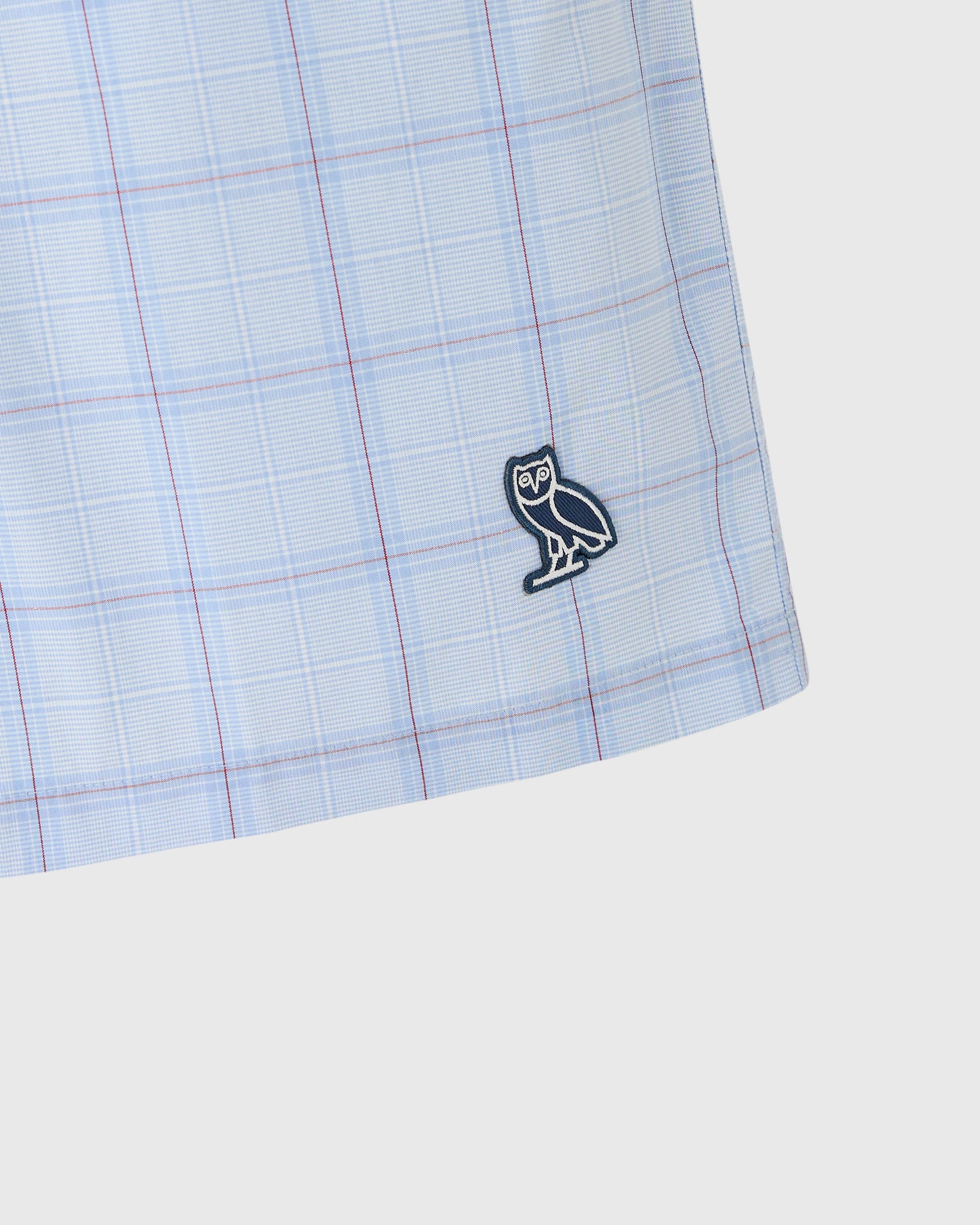 Light blue camp short with red and blue plaid pattern and owl embroidered logo.