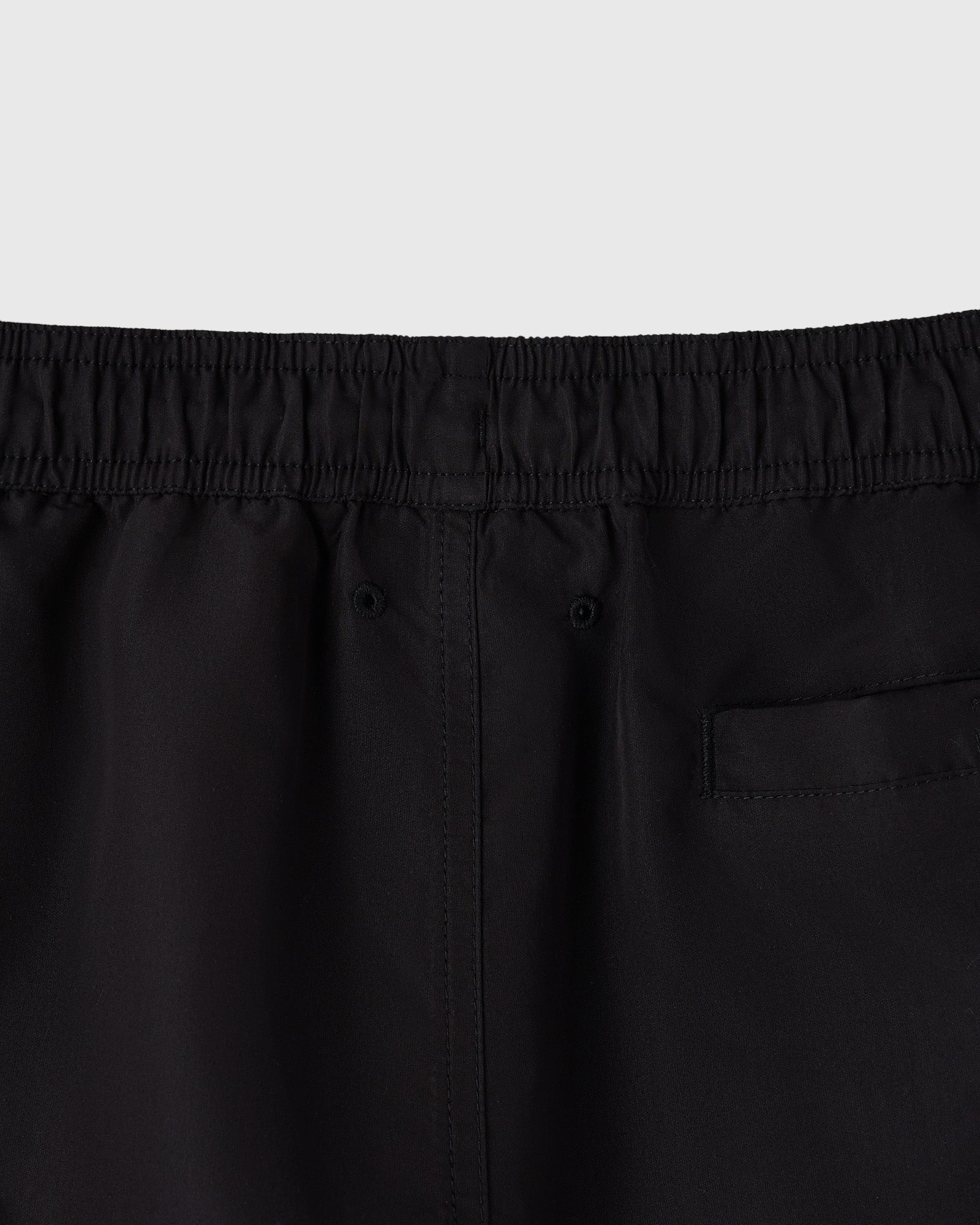Black swim shorts with elastic waistband and back pocket detail.