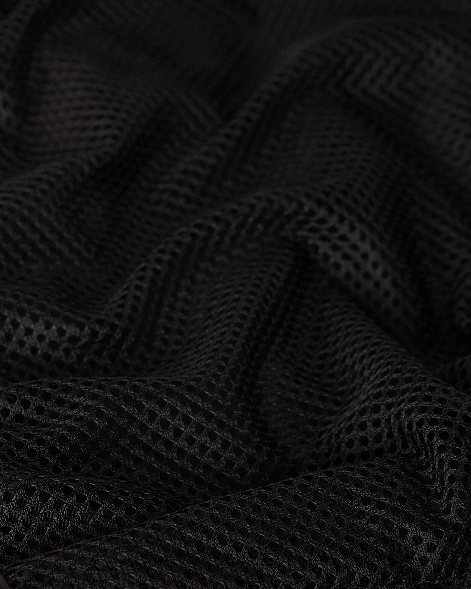 Black swim short with textured mesh fabric and draped folds.