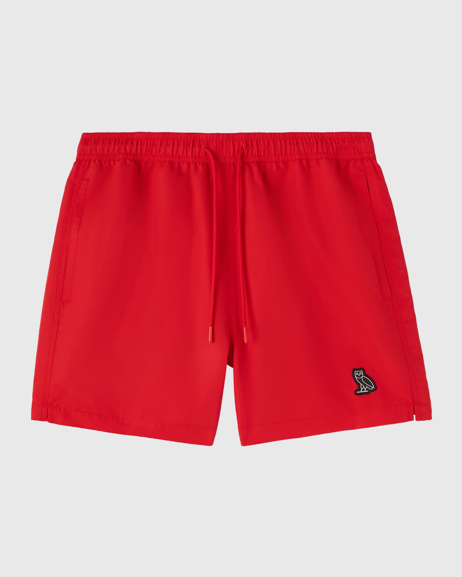 Red swim shorts with drawstring waist, side pockets, and small embroidered logo on the right leg.