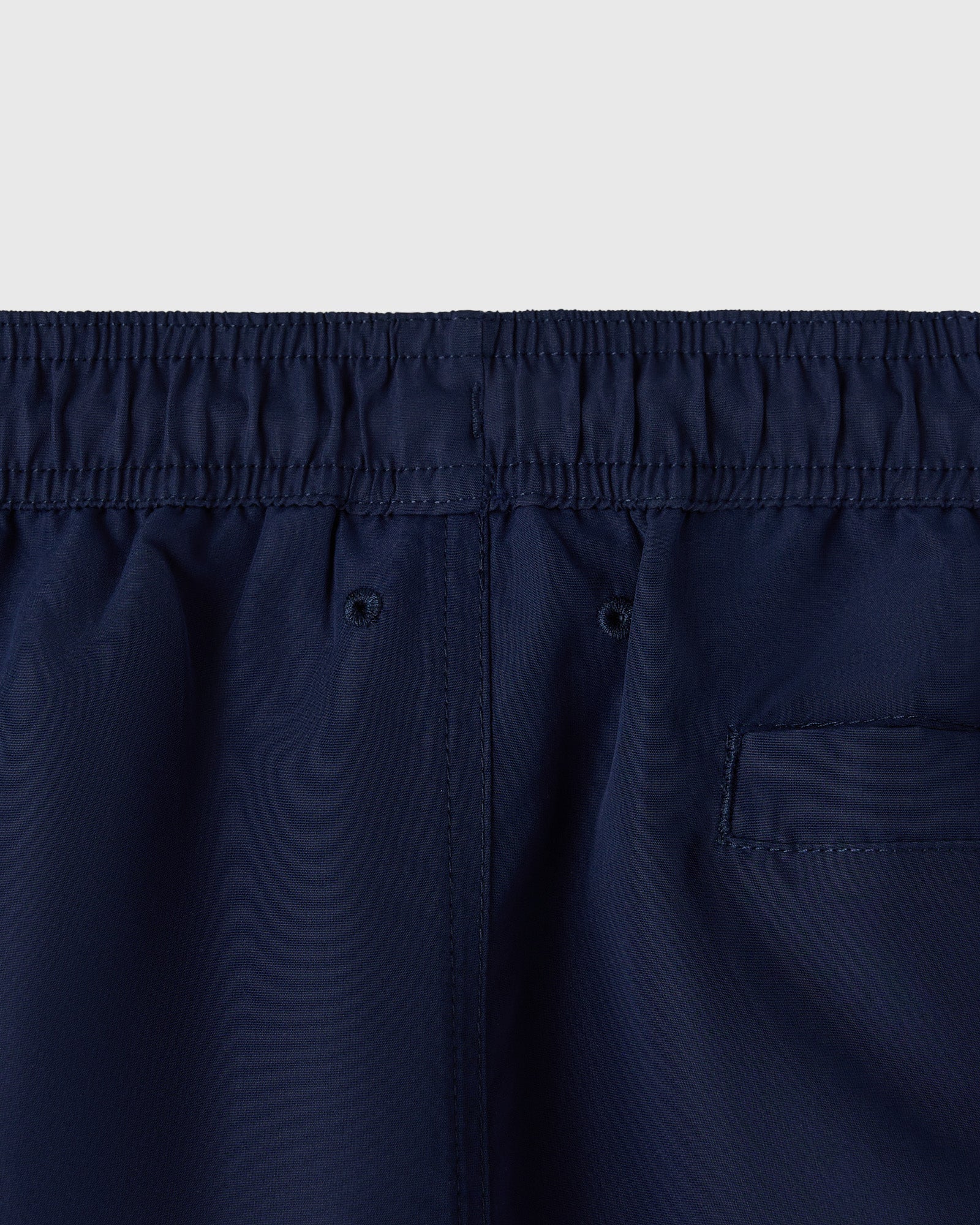 Navy swim shorts with elasticated waistband, drawstring, and rear patch pocket.