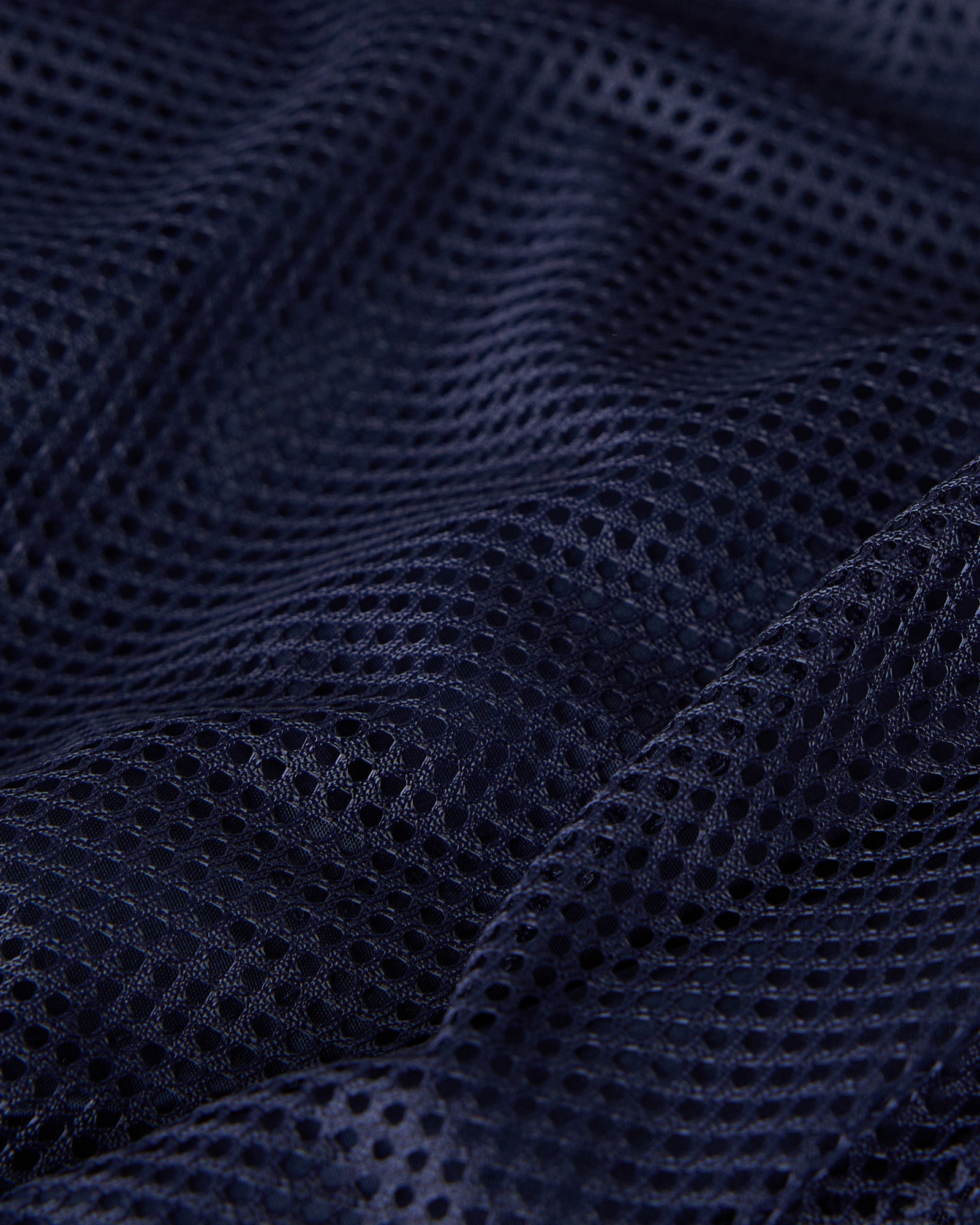 Navy mesh swim short fabric showing textured weave pattern and draping.