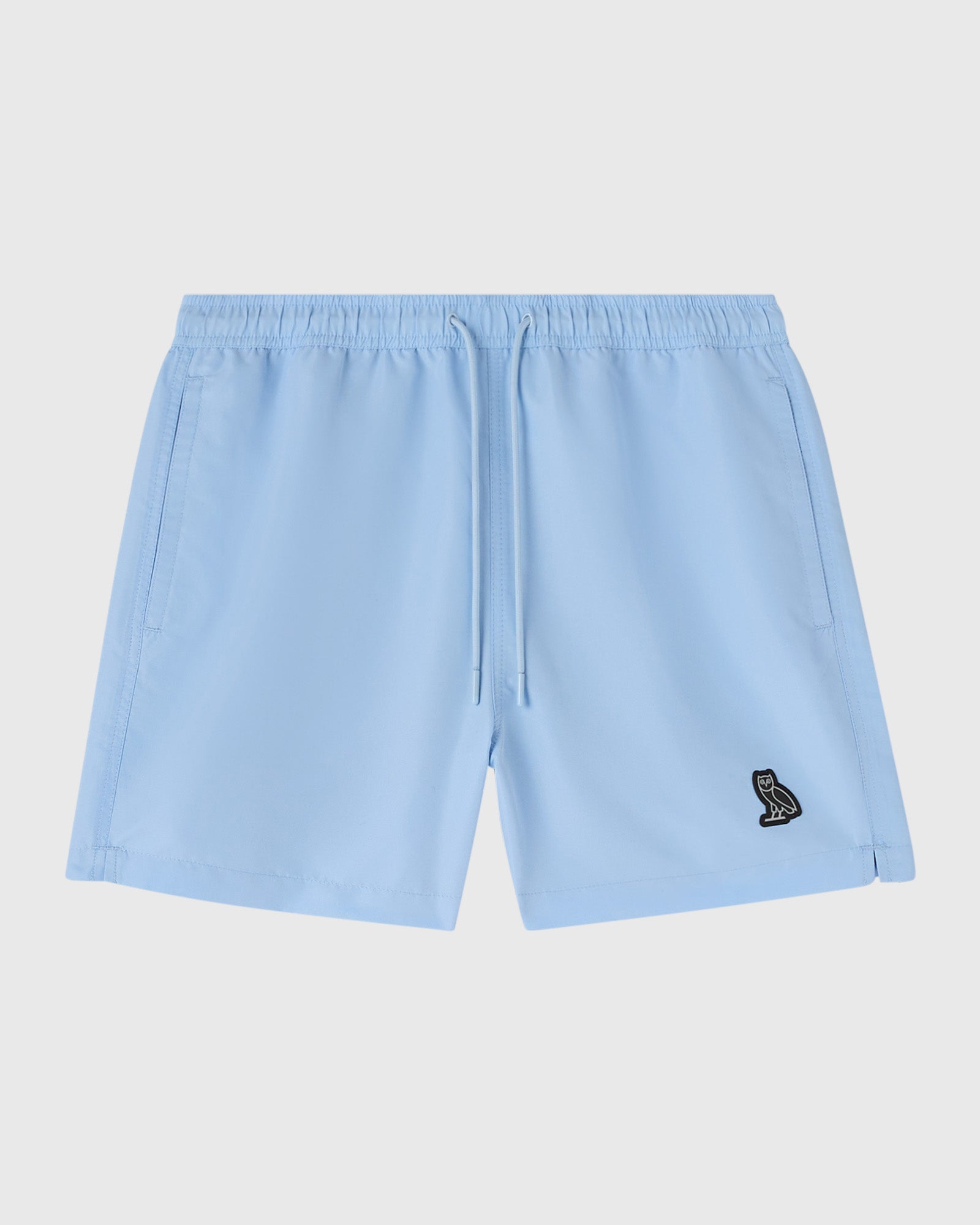 Light blue swim shorts with drawstring waist, side pockets, and small embroidered logo on thigh.