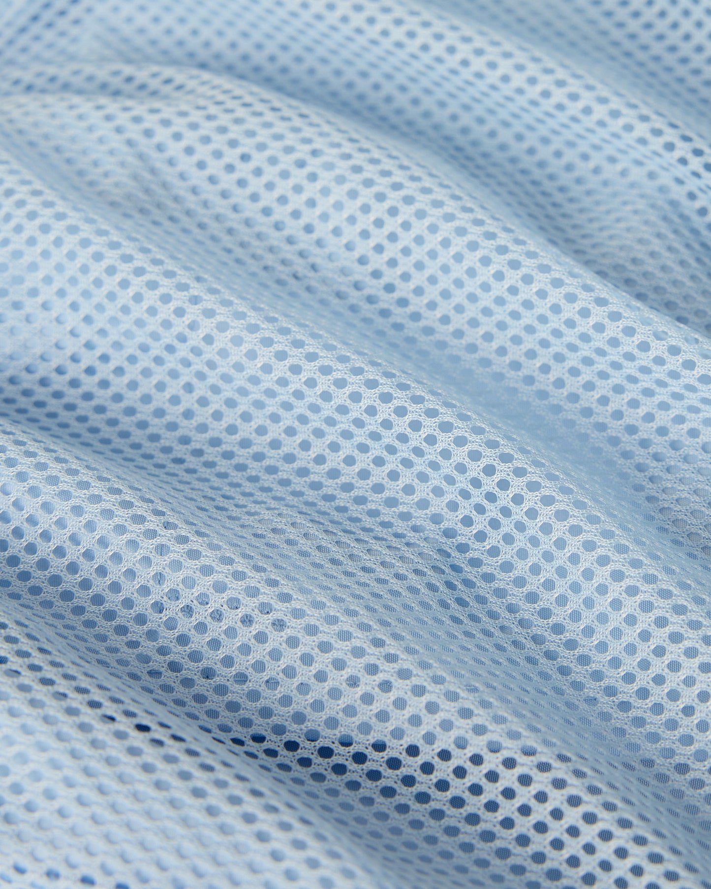 Light blue mesh fabric with textured dot pattern showing close-up weave detail.