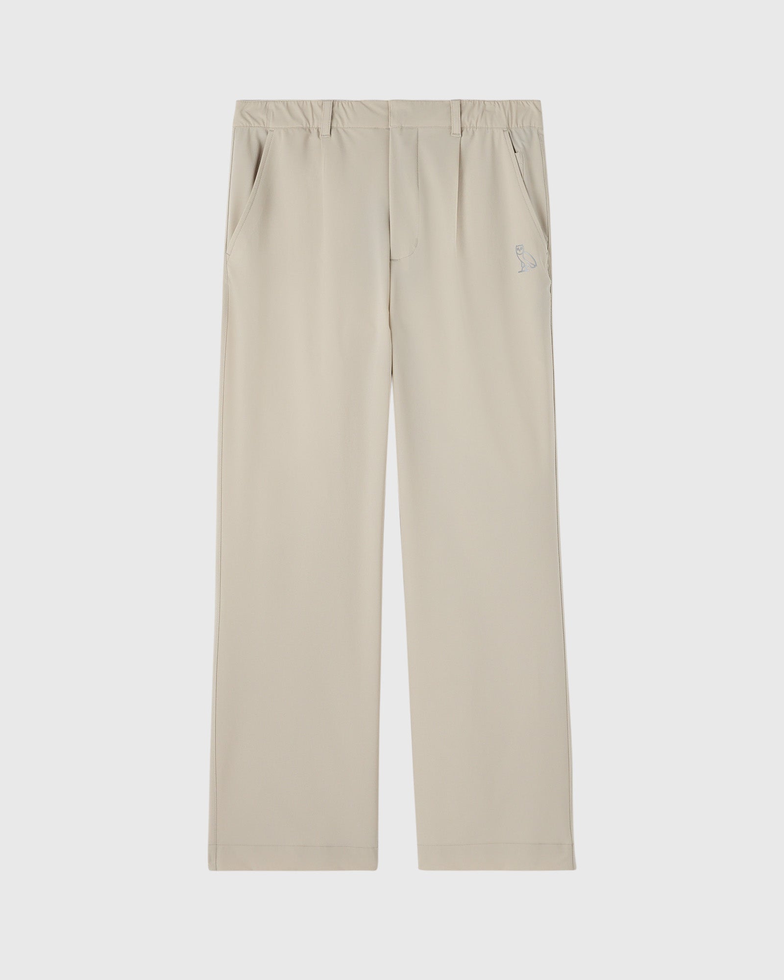 Sandstone stretch nylon chino pants with front pleats, side pockets, and small logo detail on thigh.