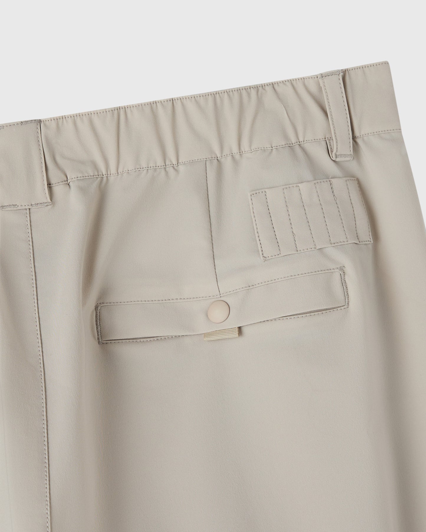Sandstone chino pants with visible waistband, belt loops, cargo pockets, and stitched details.